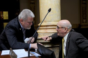 Senator Perry B. Clark (left), D-Louisville, confers with a Senate colleague during a brief recess today on the floor of the Kentucky State Senate.