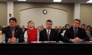 Senate Democratic Floor Leader Ray S. Jones II, right, and House Speaker Greg Stumbo, left, prepare to testify on behalf of “Noah’s Law,” legislation they filed that would have insurance companies extend coverage for therapeutic food to help citizens like nine-year-old Noah Greenhill, who is pictured at the table with his father, Eddie Greenhill.
